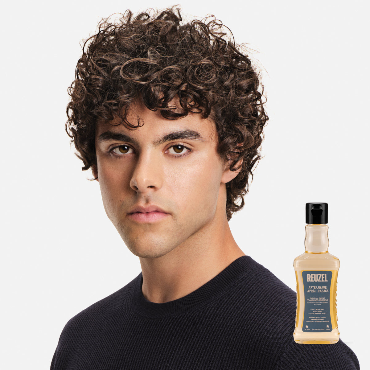 Male model with brown curly hair
Reuzel Wood & Spice aftershave used on a model with a cleanly shaved and smooth face
