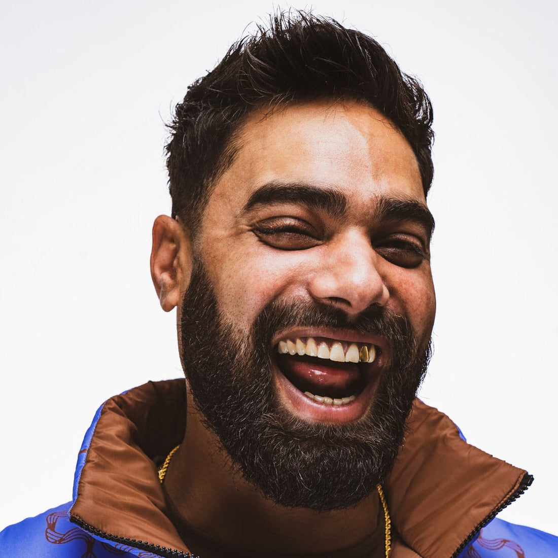 Man with well-groomed full beard smiling, showing results of quick daily beard care routine