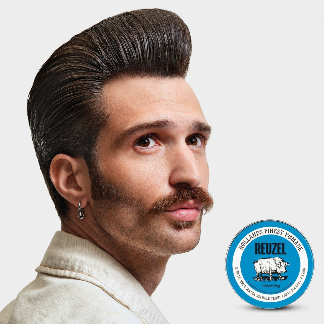 Man with slicked-back hairstyle and mustache styled using a strong-hold, high-shine REUZEL pomade