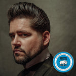 Man wearing a classic high-shine pompadour hairstyle styled with water-based pomade, illustrating the polished look achieved with REUZEL Blue Pomade.