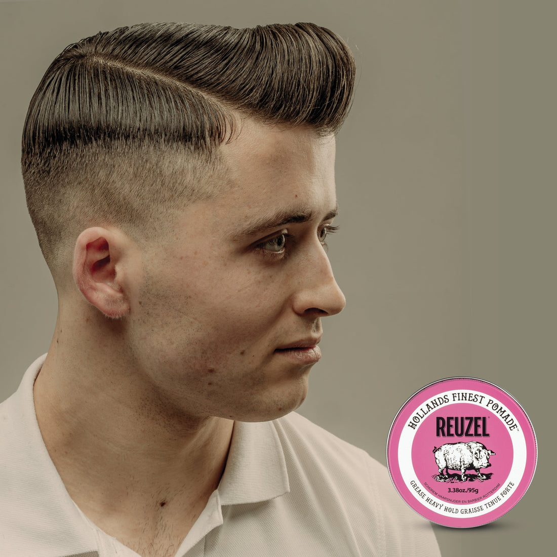 Man wearing a classic side-part pompadour styled with oil-based pomade, showing a smooth, high-shine finish and strong, pliable hold typical of traditional grease hairstyles.
