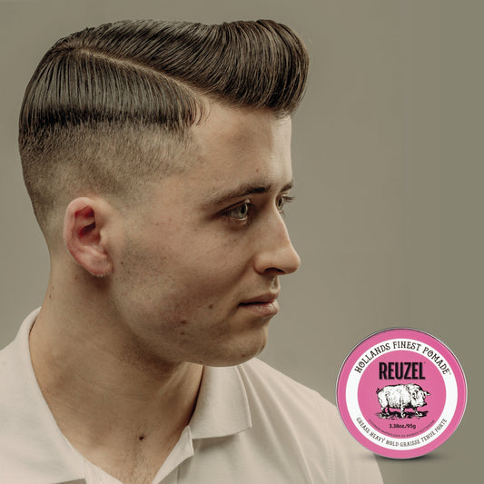 Man wearing a classic side-part pompadour styled with oil-based pomade, showing a smooth, high-shine finish and strong, pliable hold typical of traditional grease hairstyles.