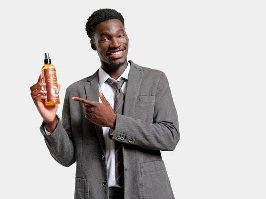 African American man holding and pointing at Reuzel's Surf Tonic Sea Salt Spray