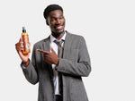 African American man holding and pointing at Reuzel's Surf Tonic Sea Salt Spray