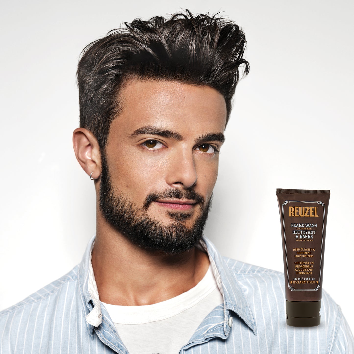 Male model with black hair and beard next to REUZEL beard wash