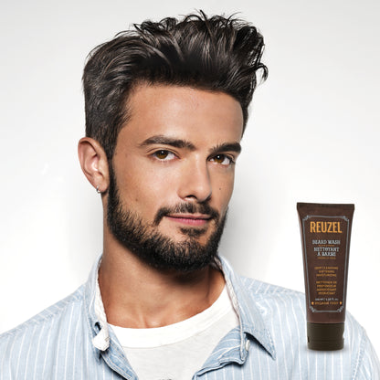 Male model with black hair and beard next to REUZEL beard wash