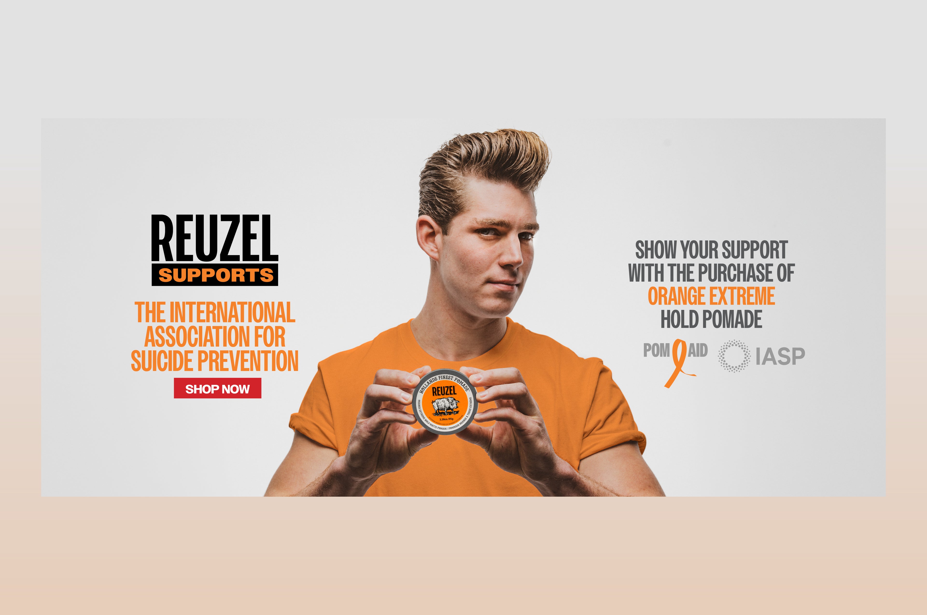 Promotional banner for REUZEL'S new Extreme Orange Pomade. Banner reads as "REUZEL SUPPORTS THE INTERNATIONAL ASSOCIATION FOR SUICIDE PREVENTION. Show your support with a purchase of orange extreme hold pomade" Logos for "pom - aid" and "IASP" featured. Red button that reads "Shop now" click the banner to shop our new product!