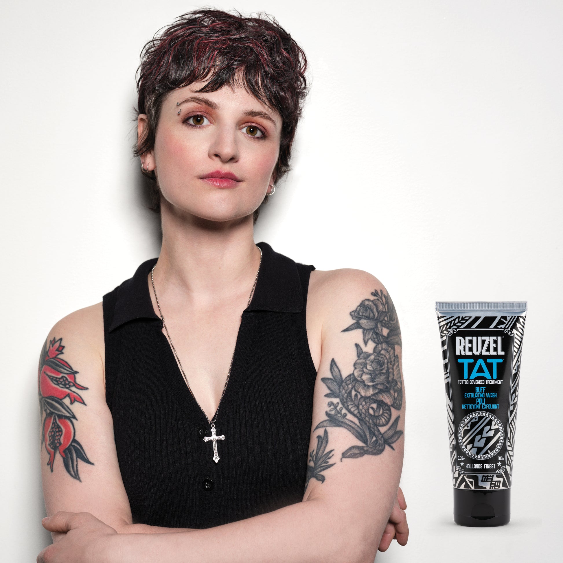 Woman with vibrant tattoos used with REUZEL TAT Buff Exfoliating Wash