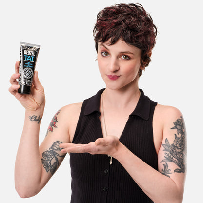 Woman with vibrant tattoos used with REUZEL TAT Buff Exfoliating Wash