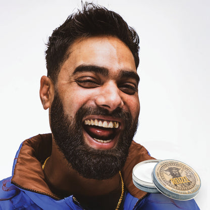 Man with brown hair and beard styled with REUZEL beard balm 