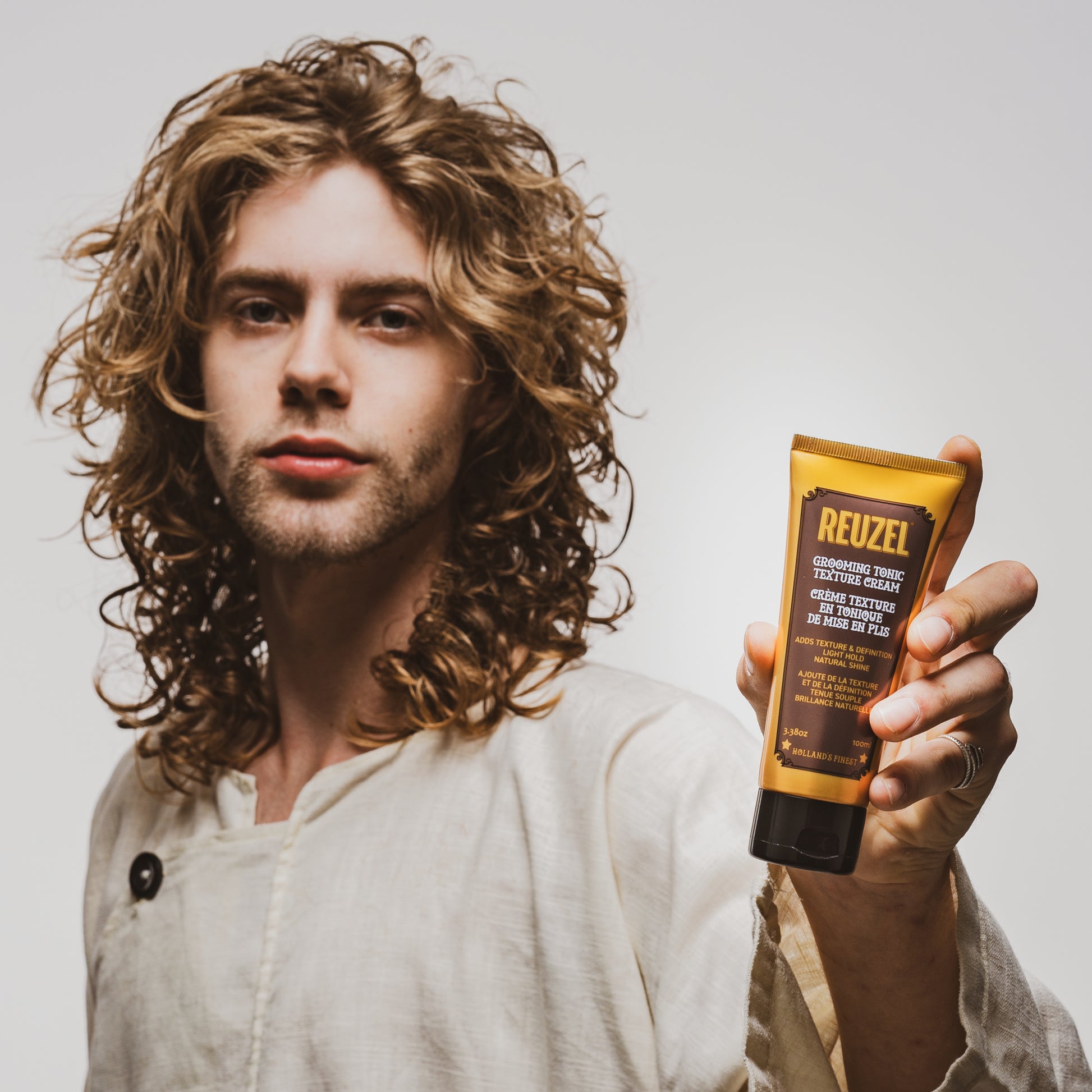 man with brown hair styled with  REUZEL Grooming Tonic Texture Cream 