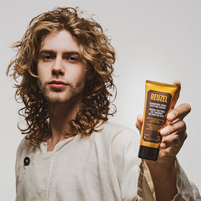 man with brown hair styled with  REUZEL Grooming Tonic Texture Cream 
