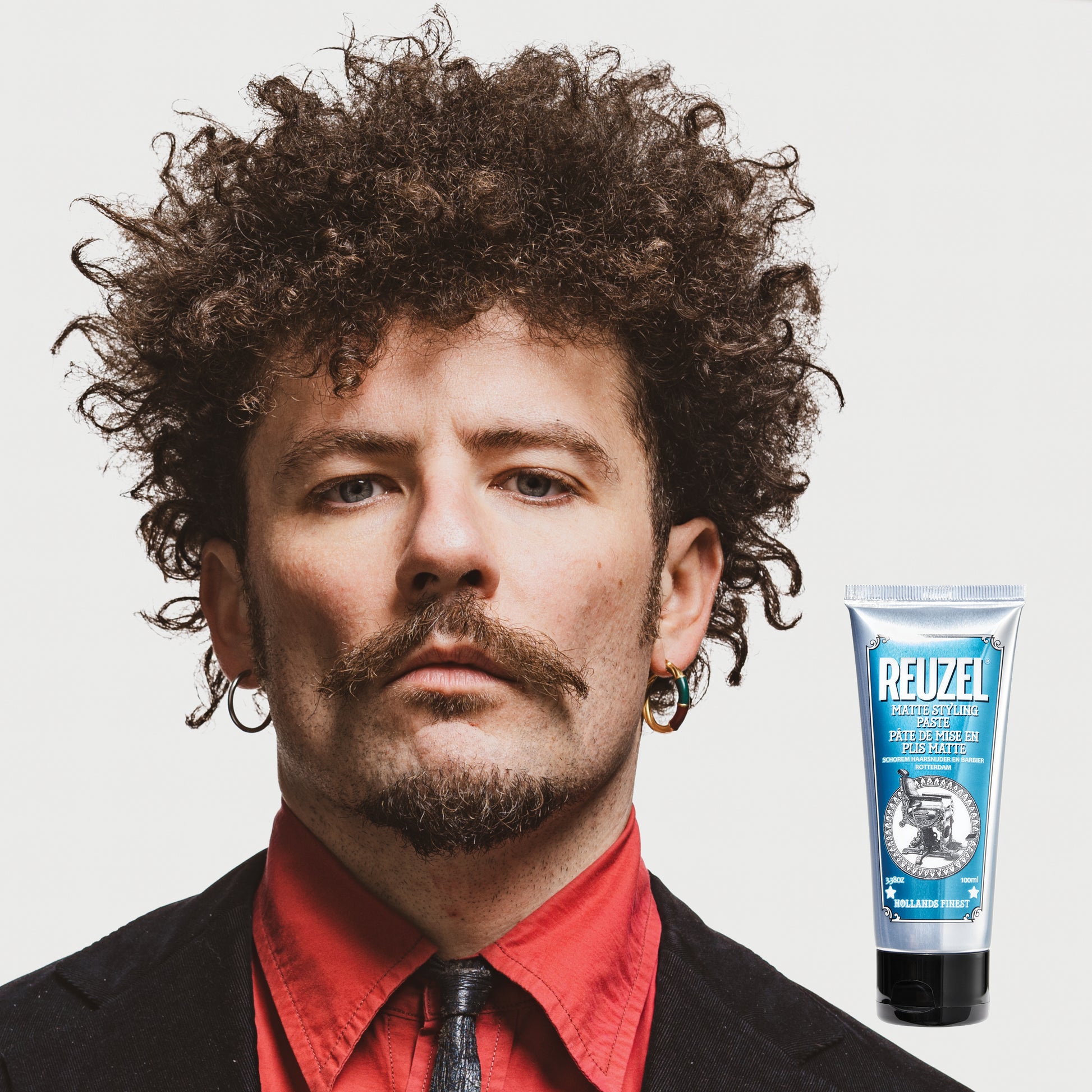Man with brown curly textured hair styled with REUZEL Grooming Cream