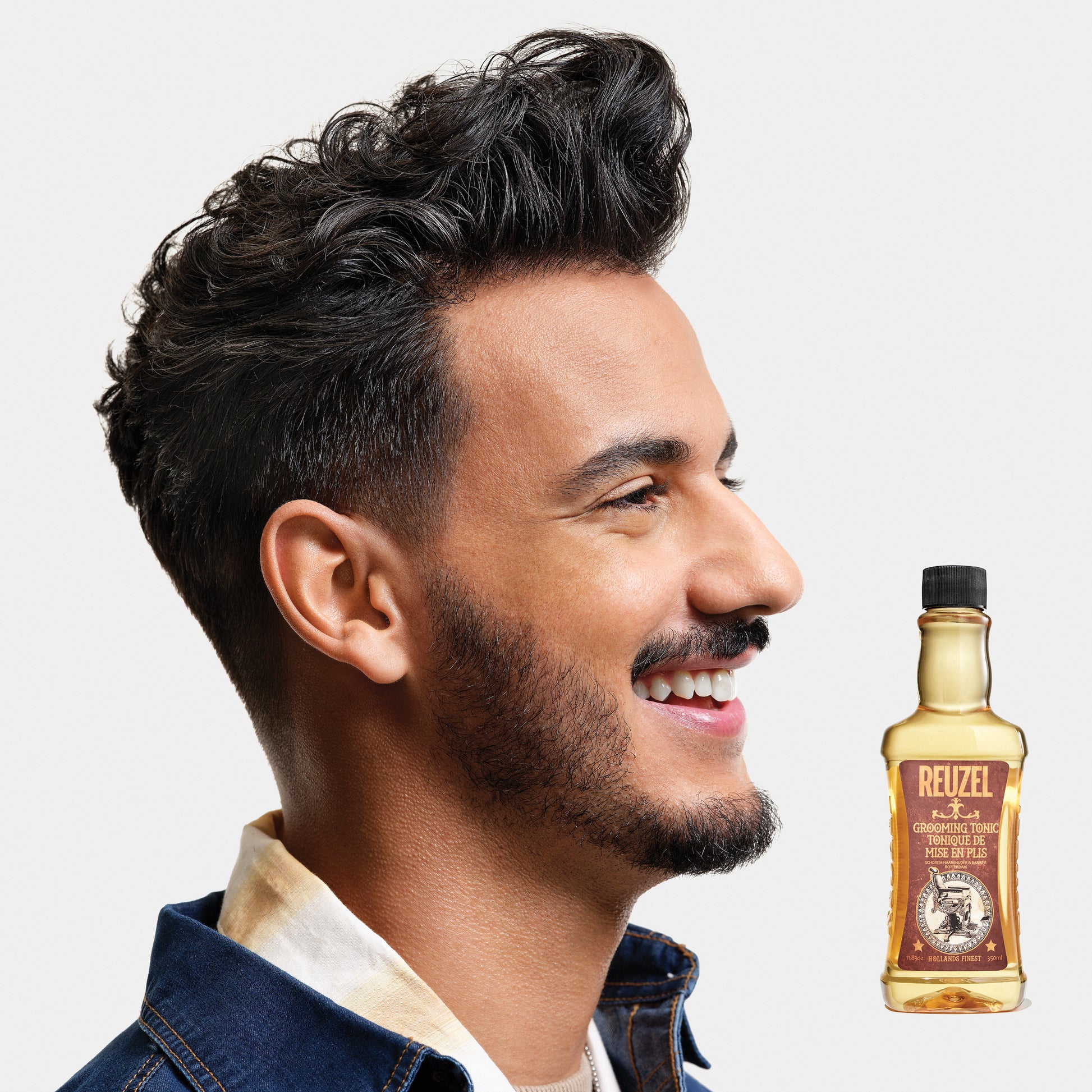 Man with brown hair styled with REUZEL Grooming Tonic
