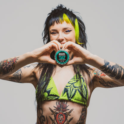 Woman with vibrant tattoos used with REUZEL TAT HYDRABALM Tattoo Balm-Tattoo Aftercare Products-REUZEL