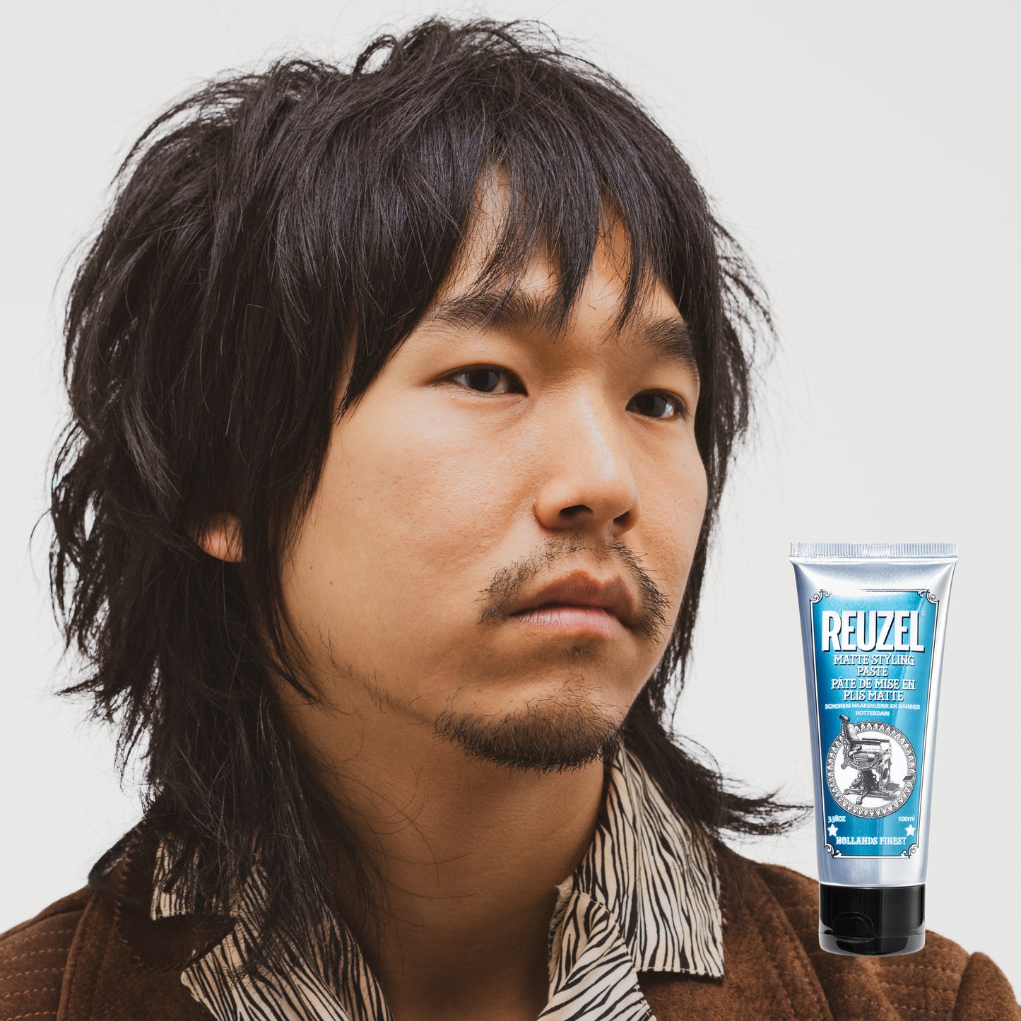Man with brown hair styled with  REUZEL matte styling paste 