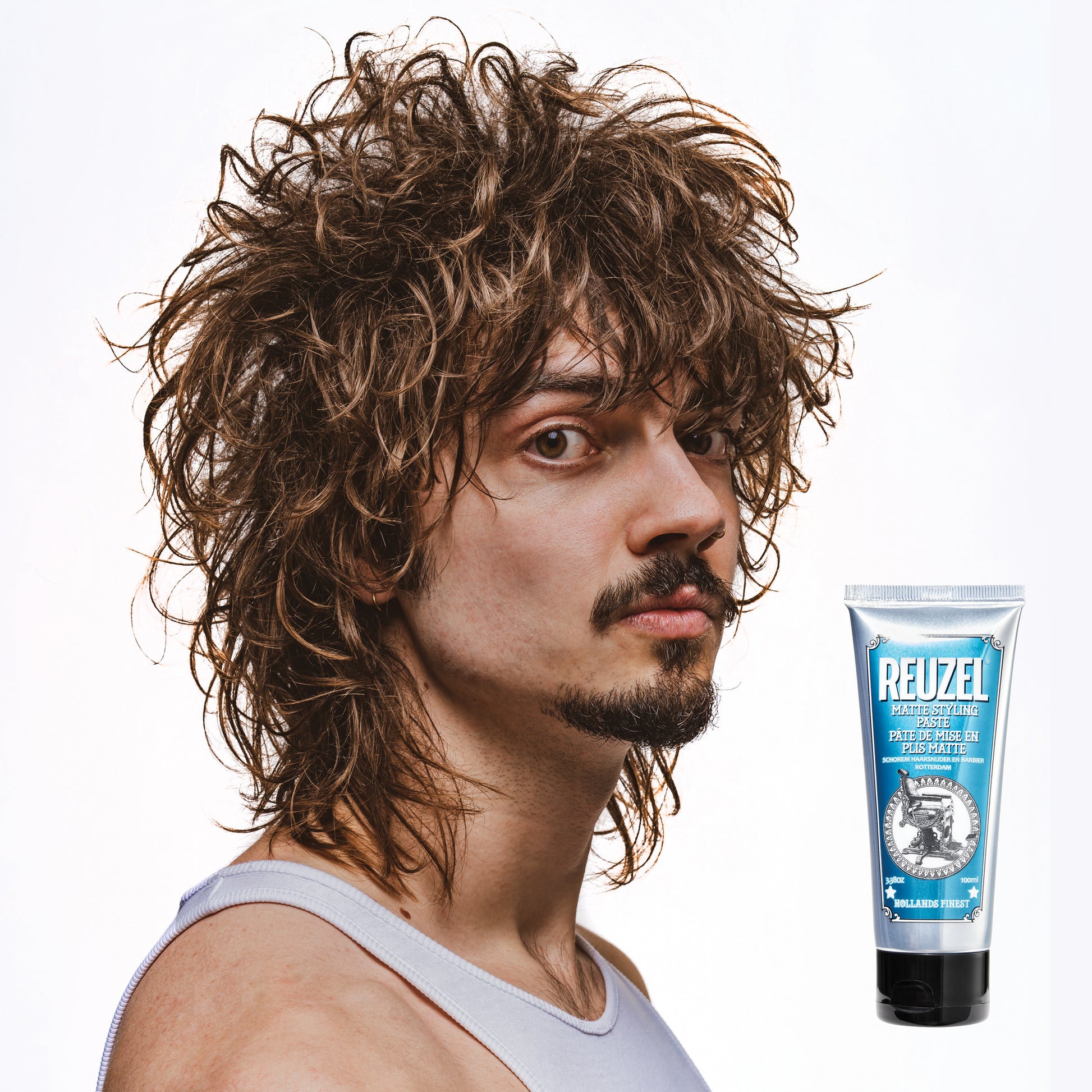 Man with brown hair styled with  REUZEL matte styling paste 