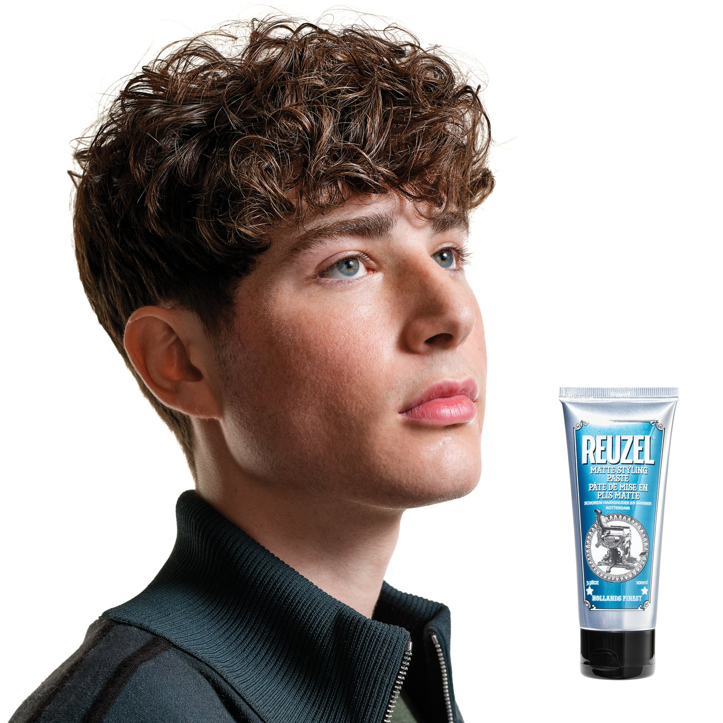 Man with brown hair styled with  REUZEL matte styling paste 