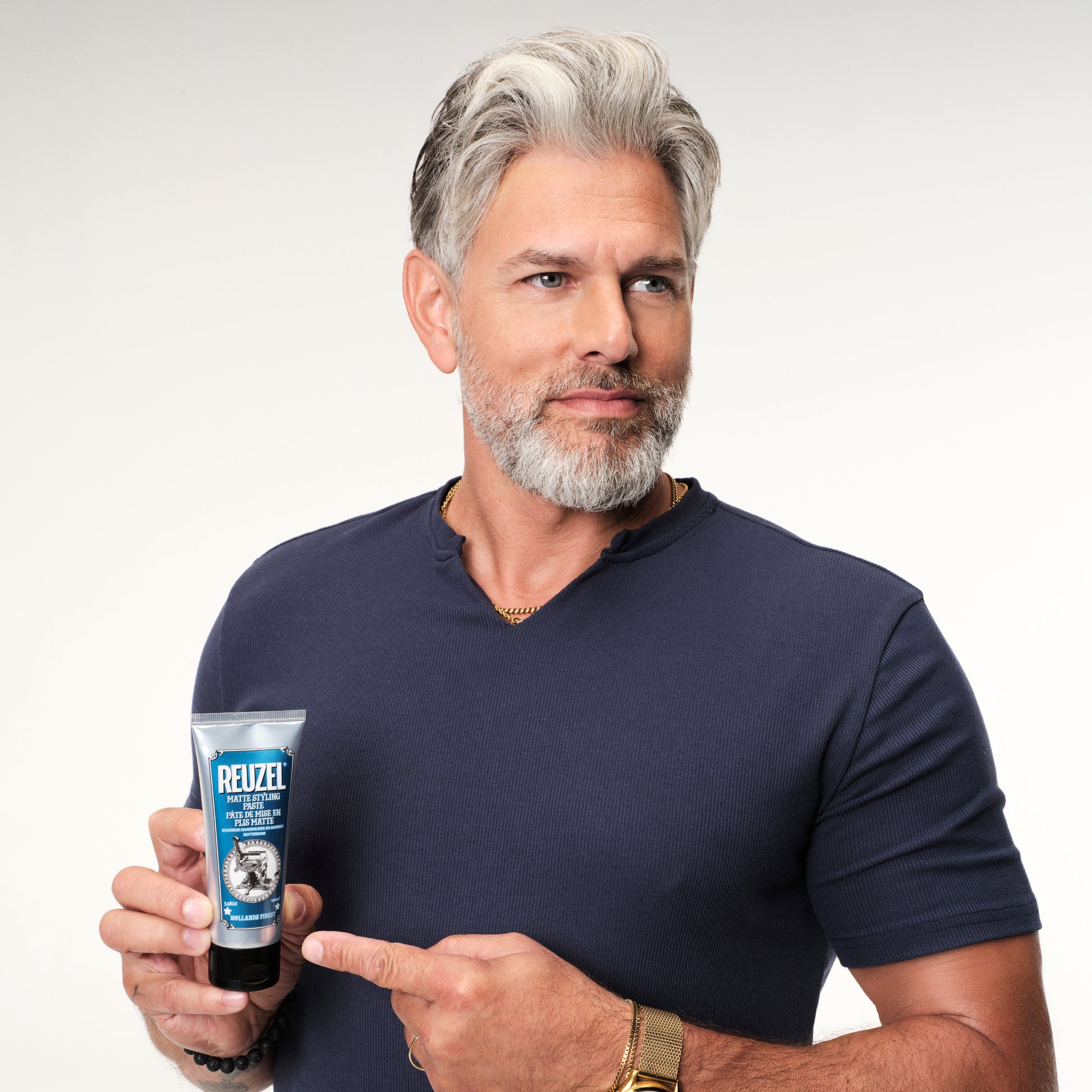 Man with grey hair styled with  REUZEL matte styling paste 