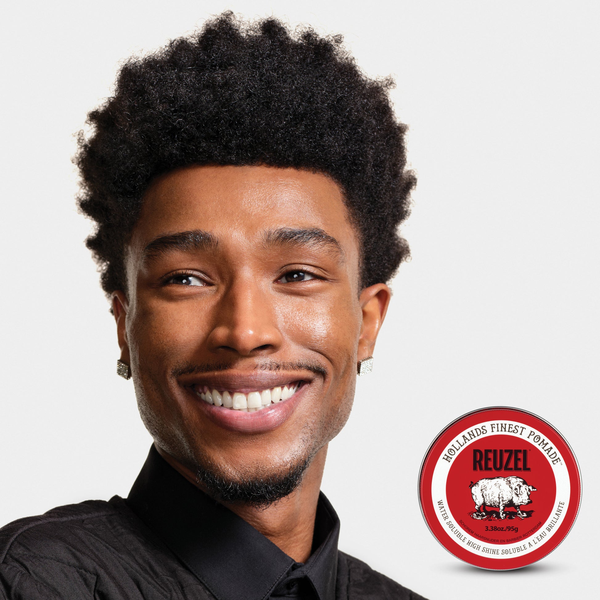 Man with brown curly textured hair styled with REUZEL Red Water-Soluble High Shine Pomade