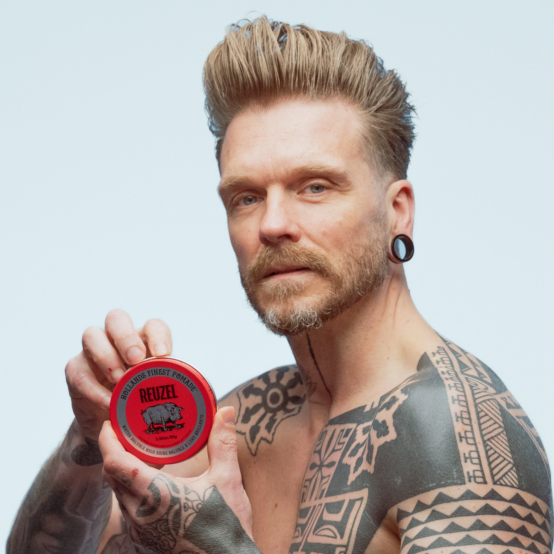Man with blonde hair styled with REUZEL Red Water-Soluble High Shine Pomade