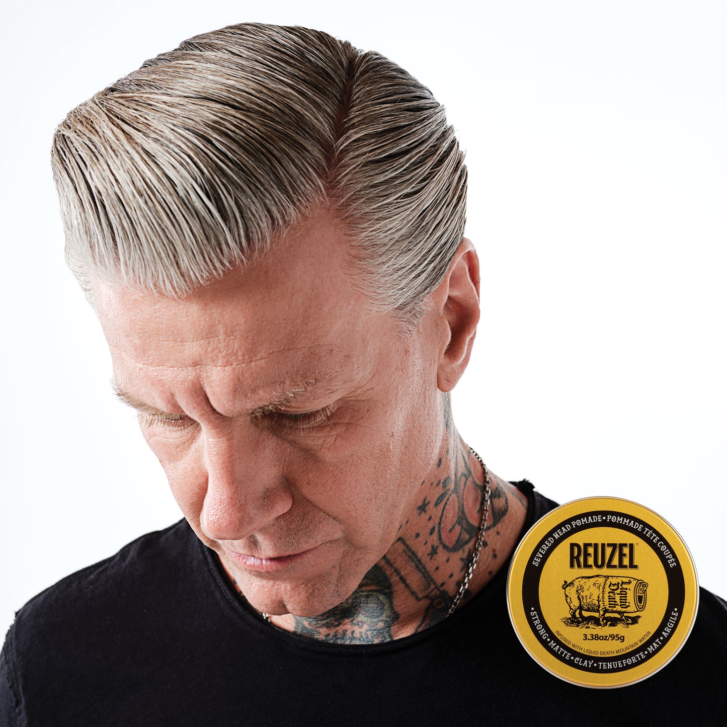 Man with grey hair styled with REUZEL Severed Head Strong Hold Matte Clay Pomade