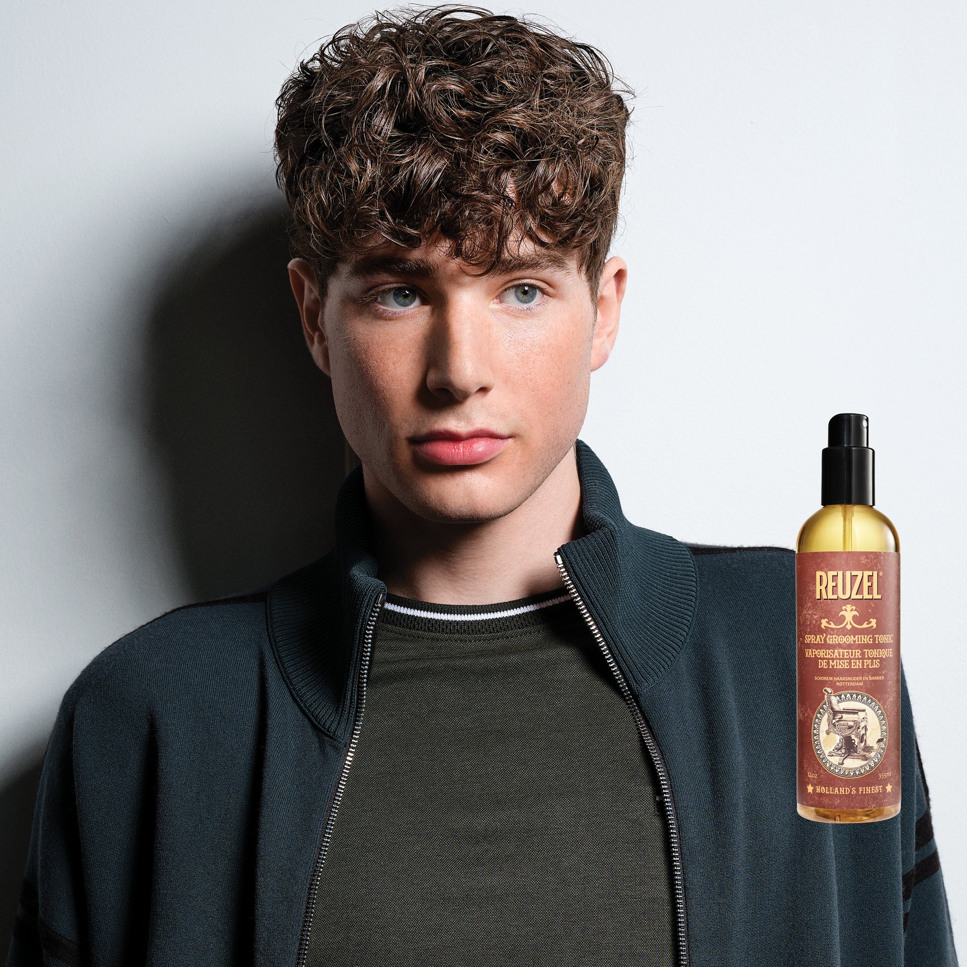 Man with brown hair styled with REUZEL Spray Grooming Tonic