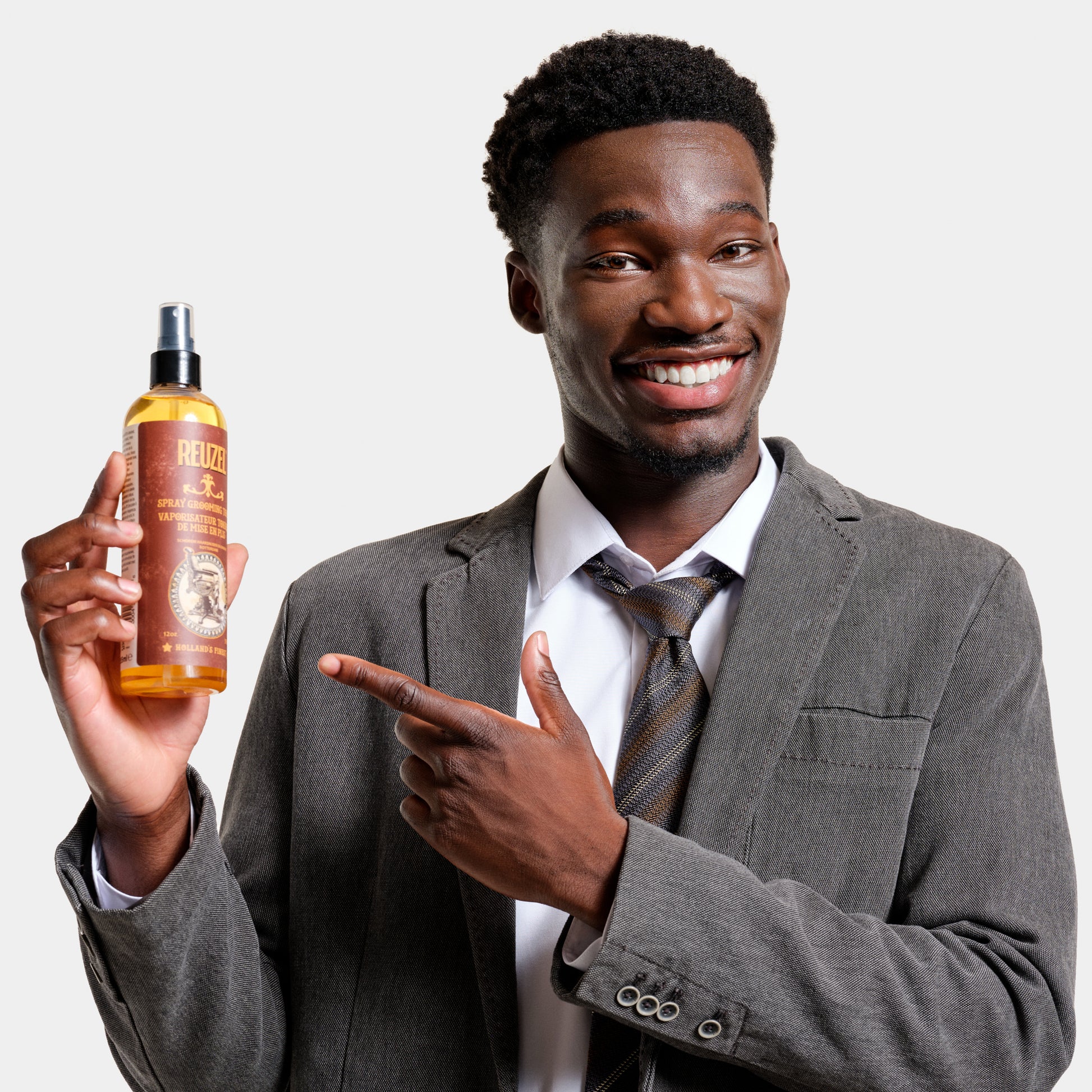 Man with brown curly textured hair styled with REUZEL Spray Grooming Tonic