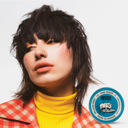 Woman with brown hair styled with REUZEL surf cream