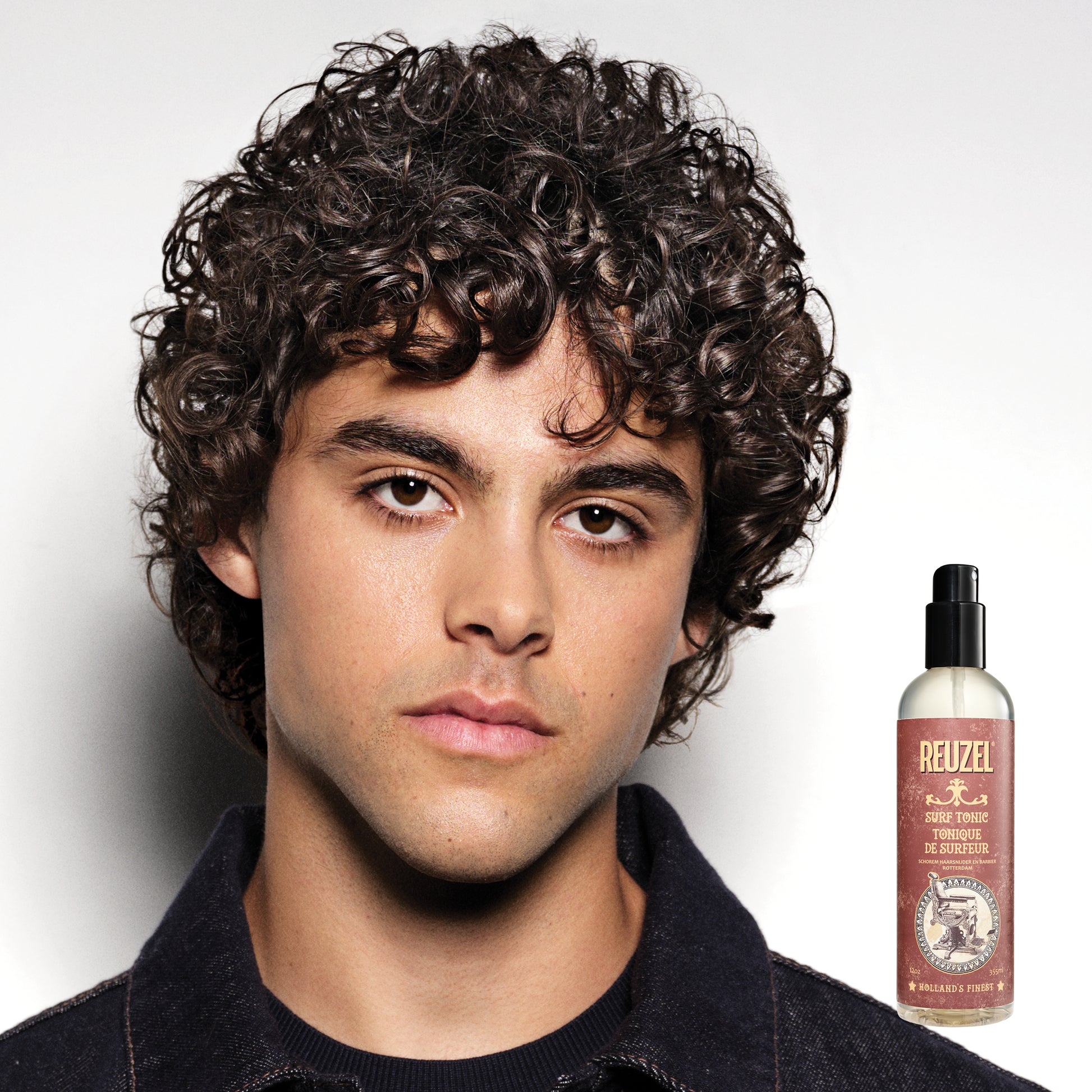 Reuzelinc Surf Tonic Salt Spray for hair, showing a clear bottle with product label, designed for textured, beachy hairstyles.