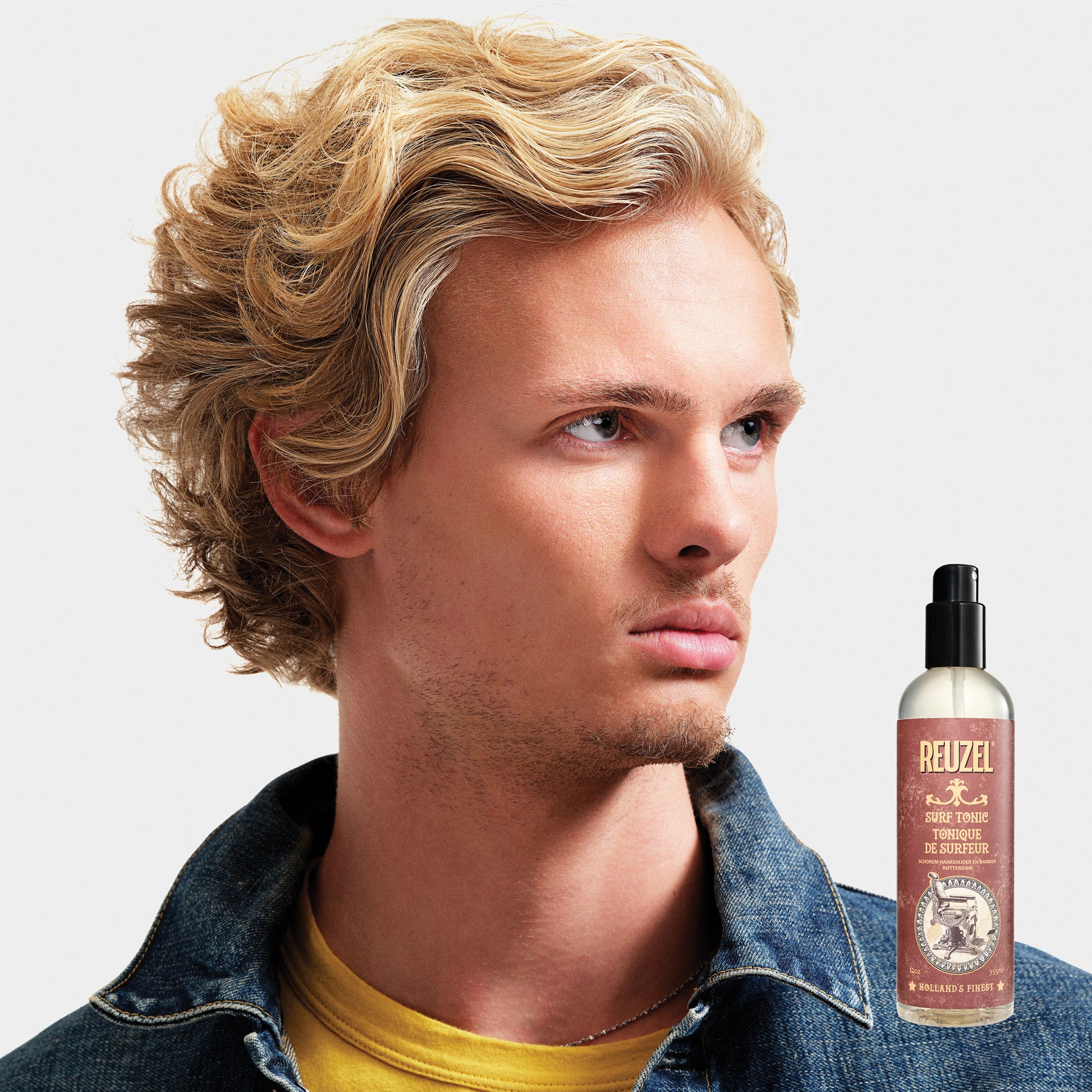 Reuzelinc Surf Tonic Salt Spray for hair, featuring a natural beachy wave look, in a clear bottle with a spray nozzle.