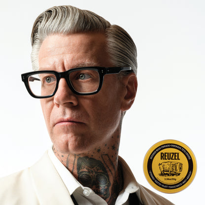 Man with styled hair next to a puck of REUZEL x Liquid Death Severed Head Strong Matte Clay Pomad on a white background