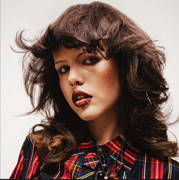 Woman with facial piercings and layered hair style