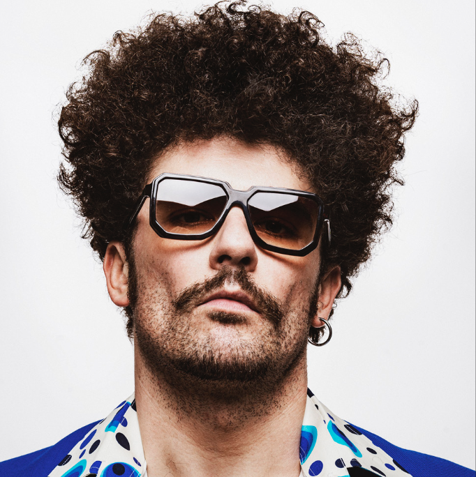 Man with beard and curly hair wearing sunglasses